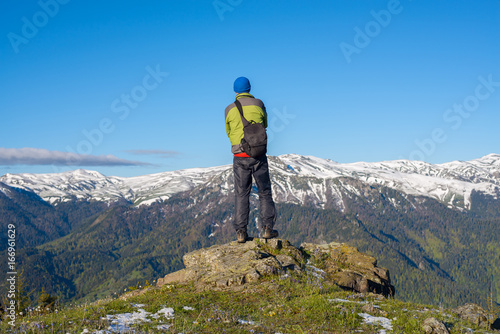 Adventurer photographer stands on a rock and meditate