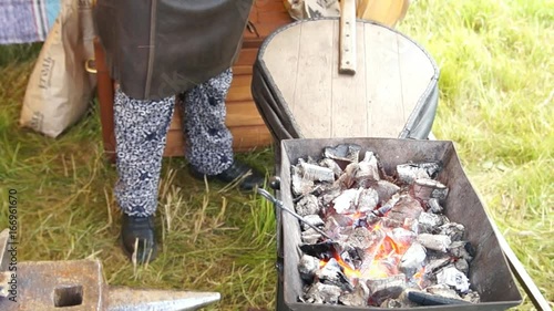 Blacksmith blows coals
