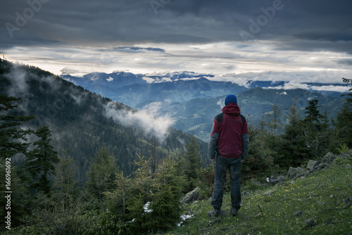 Meditating adventurer admiring epic view of the mountains © sanechka
