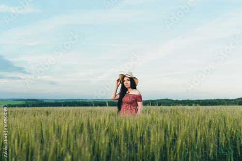Beautiful young woman at sunset in the field