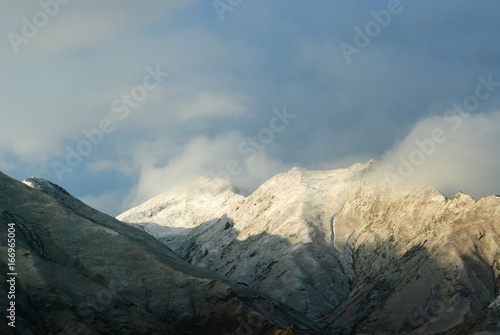 Snowy mountains in clouds in Tibet panorama view