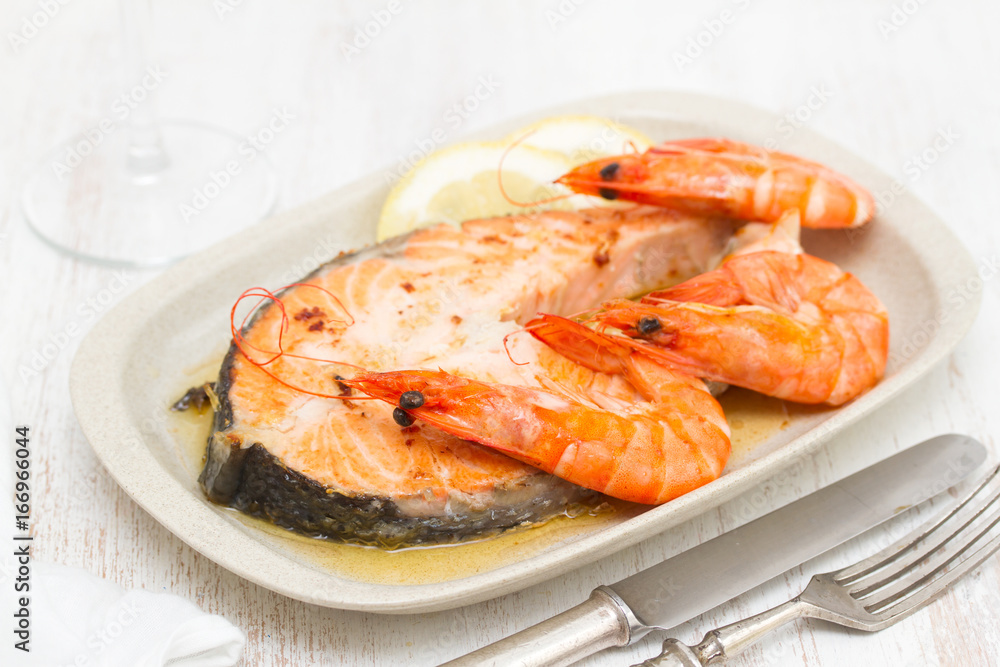 fried salmon with shrimps on white dish on wooden background fried salmon with shrimps on white dish on wooden background