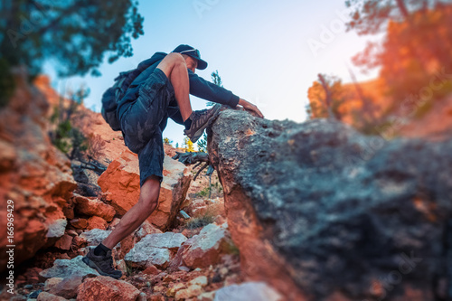 Hiker climbs rocky steep terrain