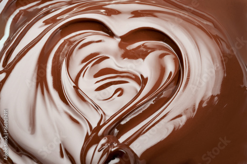 Melted chocolate heart. Swirl chocolate splash background.