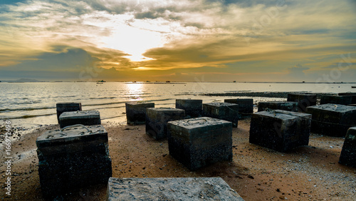 Concrete block at beach with sunset sky at sea