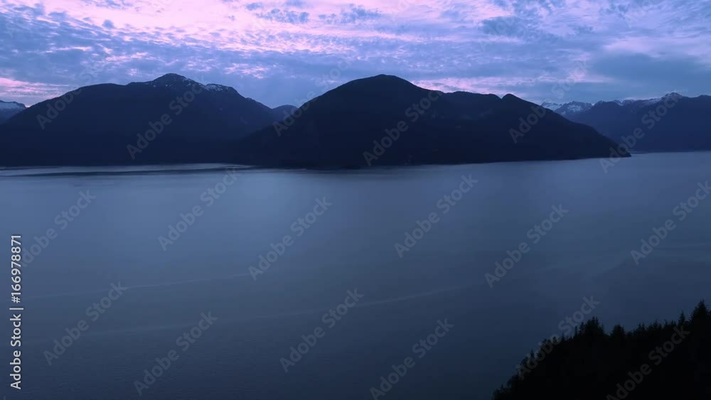 British Columbia Evening Aerial with Mountain Islands in Ocean by Silhouette Forest British Columbia Evening Aerial with Mountain Islands in Ocean by Silhouette Forest