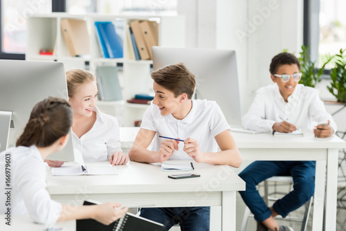 multicultural students having conversation together during class in classroom