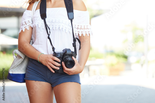 Tourist with photo camera shooting on the street