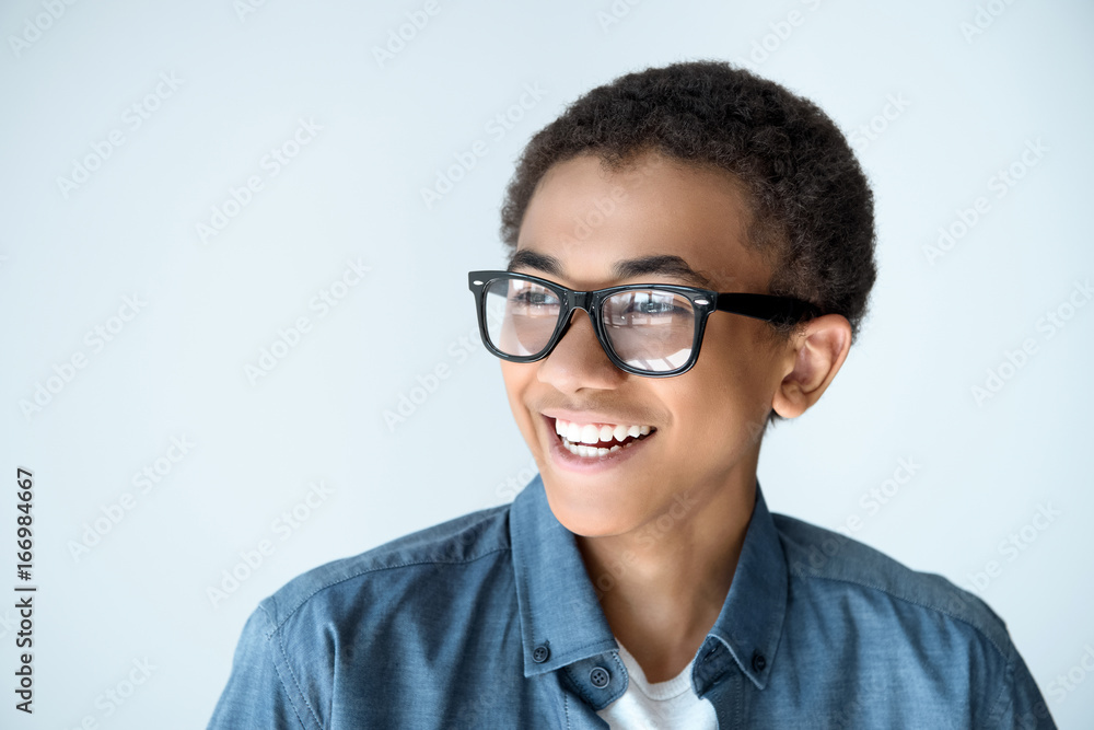 portrait of cheerful african american teenage boy in eyeglasses looking away isolated on white portrait of cheerful african american teenage boy in eyeglasses looking away isolated on white