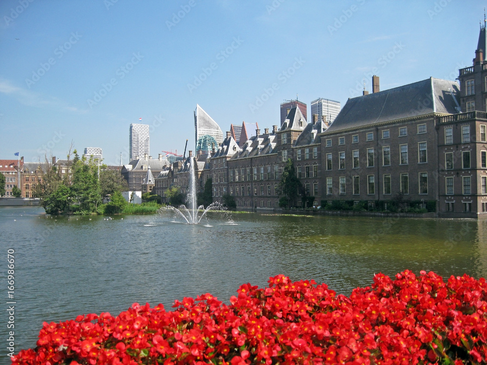 View of the Dutch parliament or Binnenhof in Dutch behind a fence of flower and a pond, The Hague, Netherlands