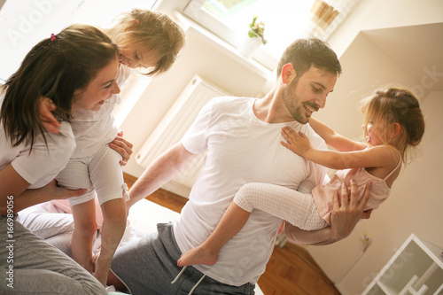 Happy family having fun on bed.