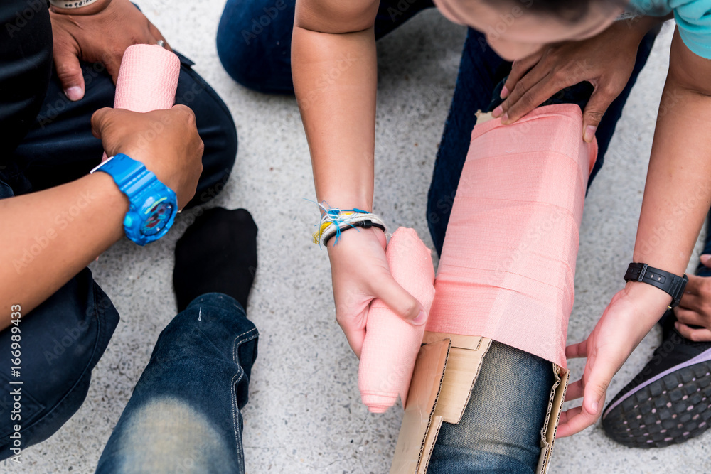 At First Aid Training Classroom, Students are trying to splint the leg of a  patient's broken leg incident with cardboard and elastic bandage. Stock  Photo | Adobe Stock
