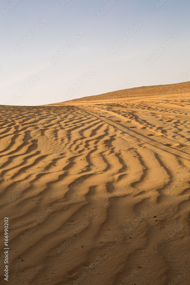 Naklejka premium A huge blue summer sky sky, over a beautiful golden desert sand dune. Sand textures.