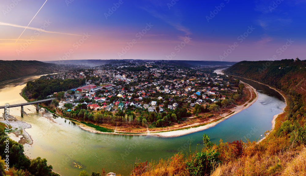 Panoramic view from above to famous ukraininan city Zaleshchiki in the Dnister river canyon at sunset. Ukraine, Ternopil region