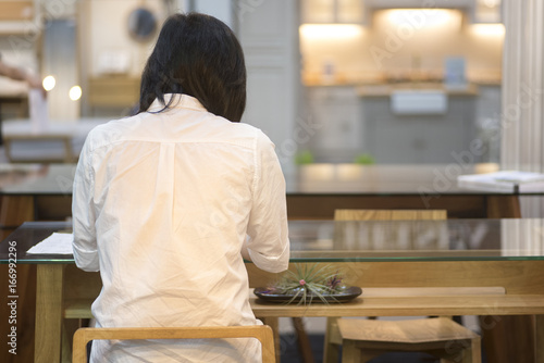 Woman sitting back alone in a coffee shop