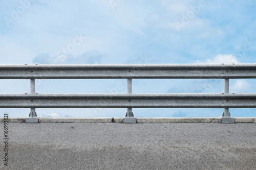 railing at road side on blue sky background