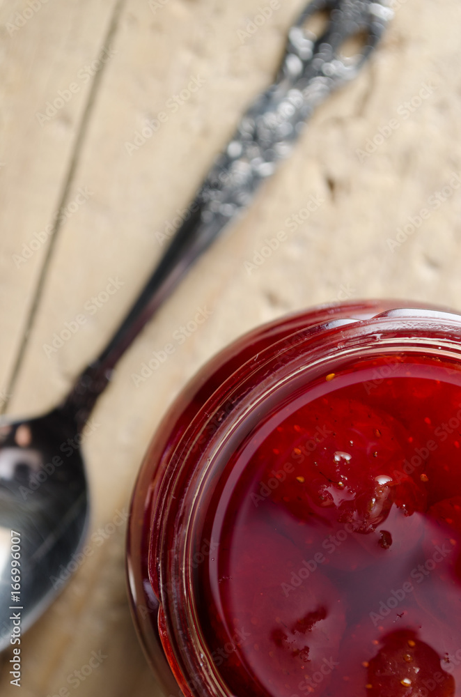 Strawberry Jam and Spoon on a Wooden Table Strawberry Jam and Spoon on a Wooden Table