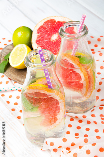 Infused flavored water with fresh fruits on white wooden background.Refreshing summer homemade  detox water
