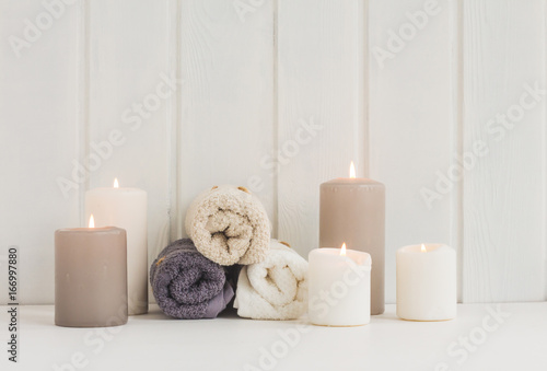 Spa composition. Spa candles. towels on rustic white wooden background.