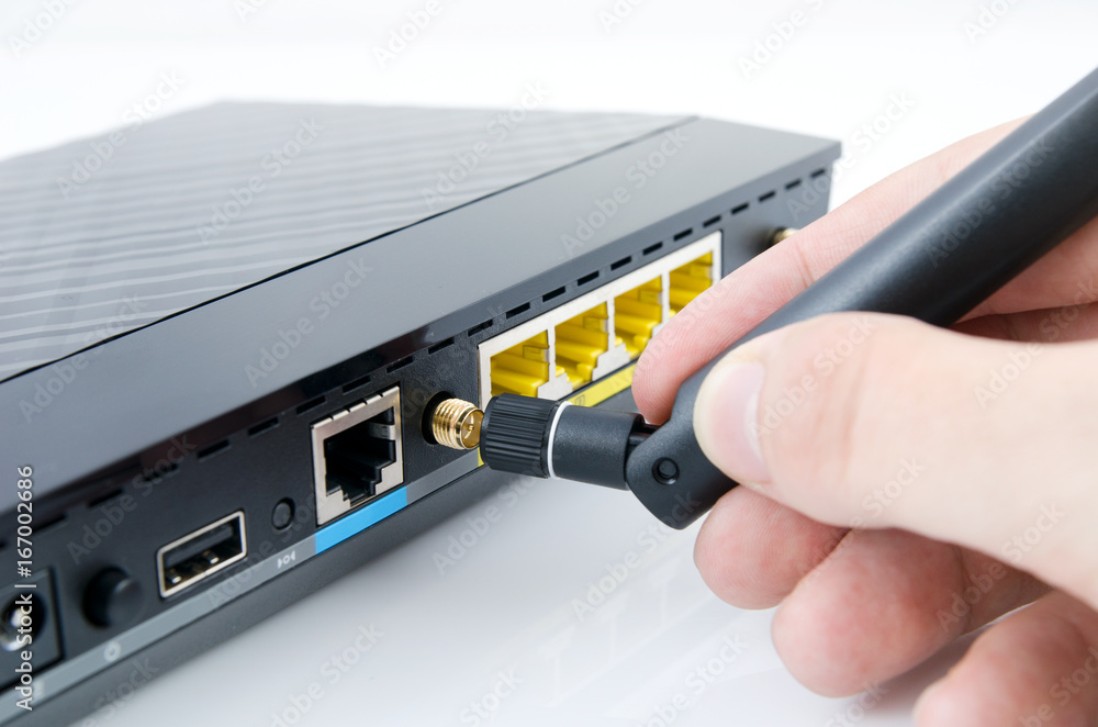 Man connecting antenna to Wi-Fi router Man connecting antenna to Wi-Fi router