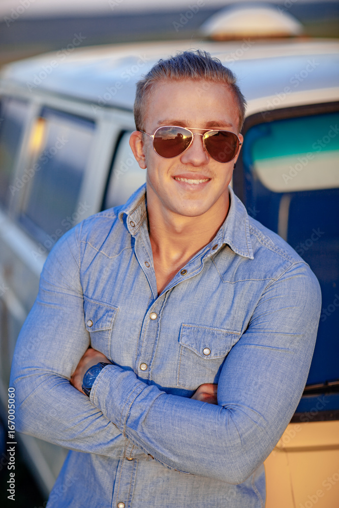 A guy is standing by the car. A guy is standing by the car.