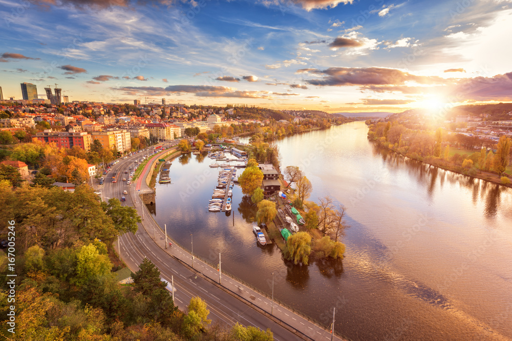 Autumn in Prague, golden sunset from popular view point, Vyshehrad. Aerial view to the residential area, Vltava river with islands and beautiful blue cloudy sky and sun, Czech Republic