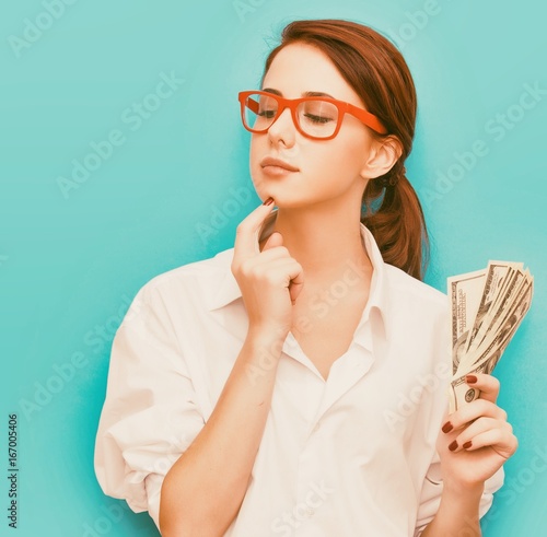 Portrait of redhead woman in red glasses with money