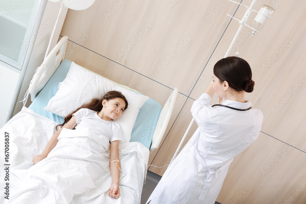 Joyful pleasant girl looking at her doctor Joyful pleasant girl looking at her doctor