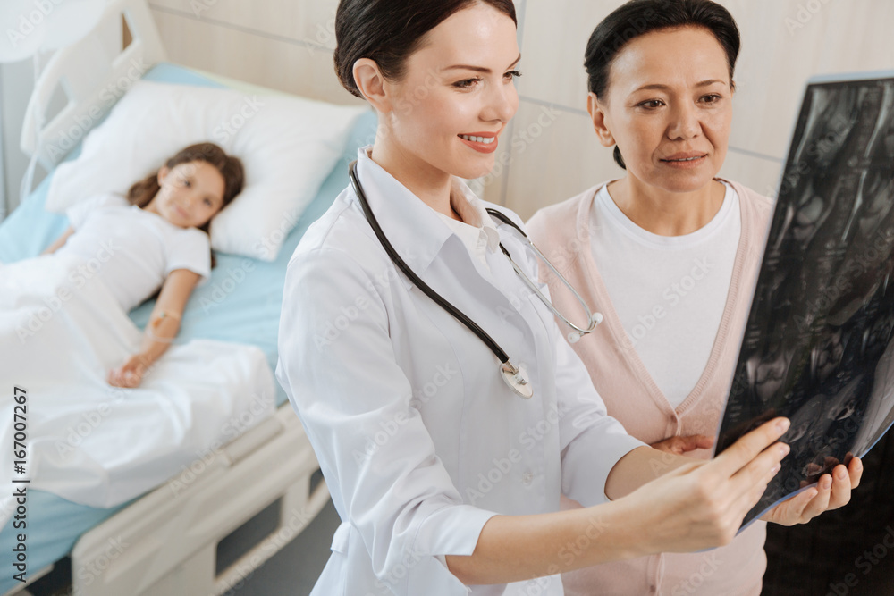 Happy professional doctor standing with her patients mother Happy professional doctor standing with her patients mother