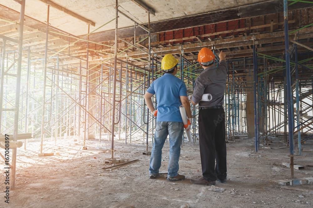 Engineer discussing with foreman about project in building construction site Engineer discussing with foreman about project in building construction site