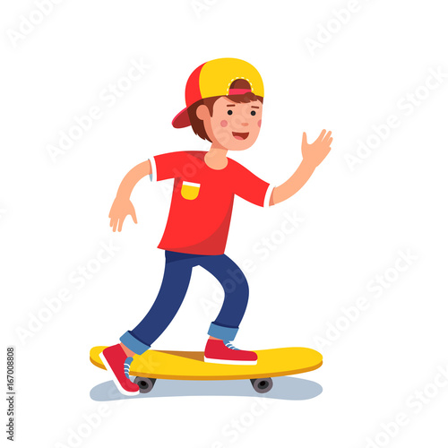 Teen boy in baseball cap riding on skateboard