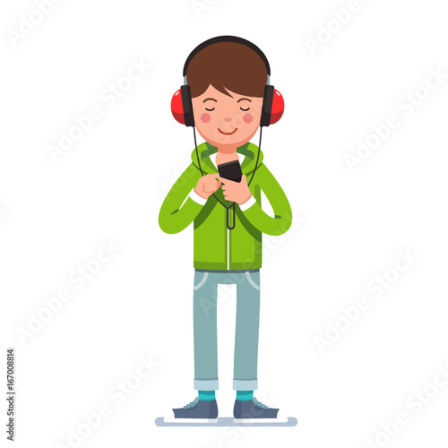 Teen boy in headphones listening to music on phone