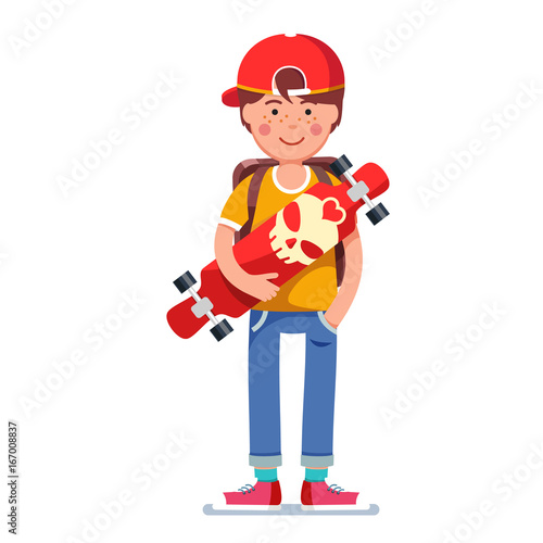 Teen boy in cap standing and holding skateboard