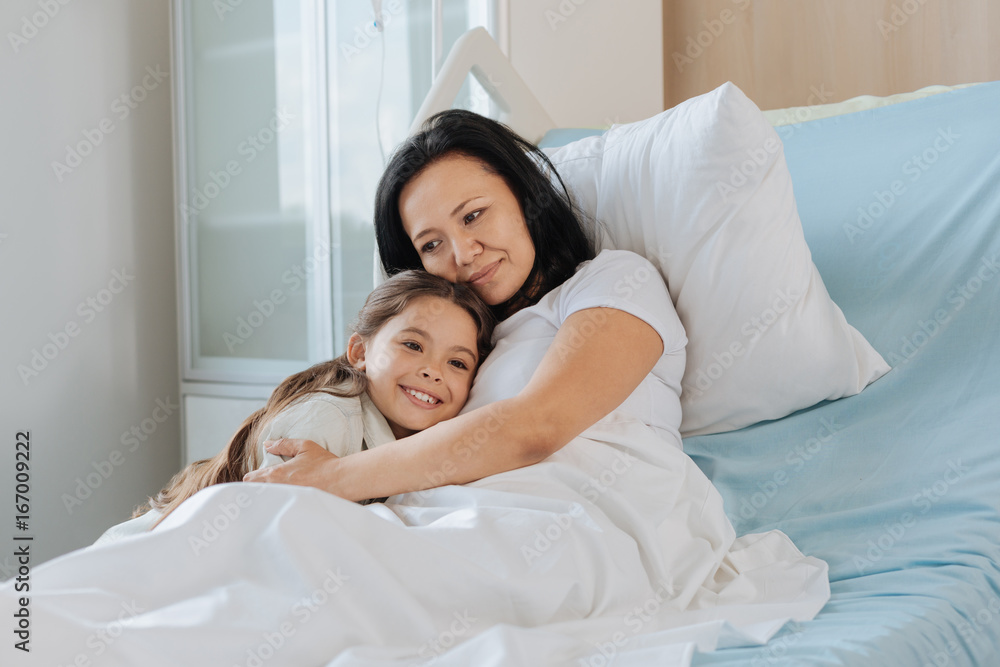 Fototapeta premium Pleasant delighted woman hugging her child