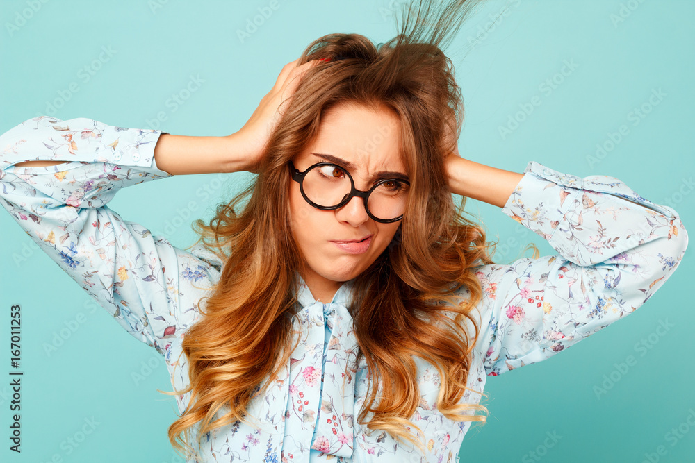 Φωτογραφία Funny young pretty woman holding hands on her head and trying to blow away hairs
