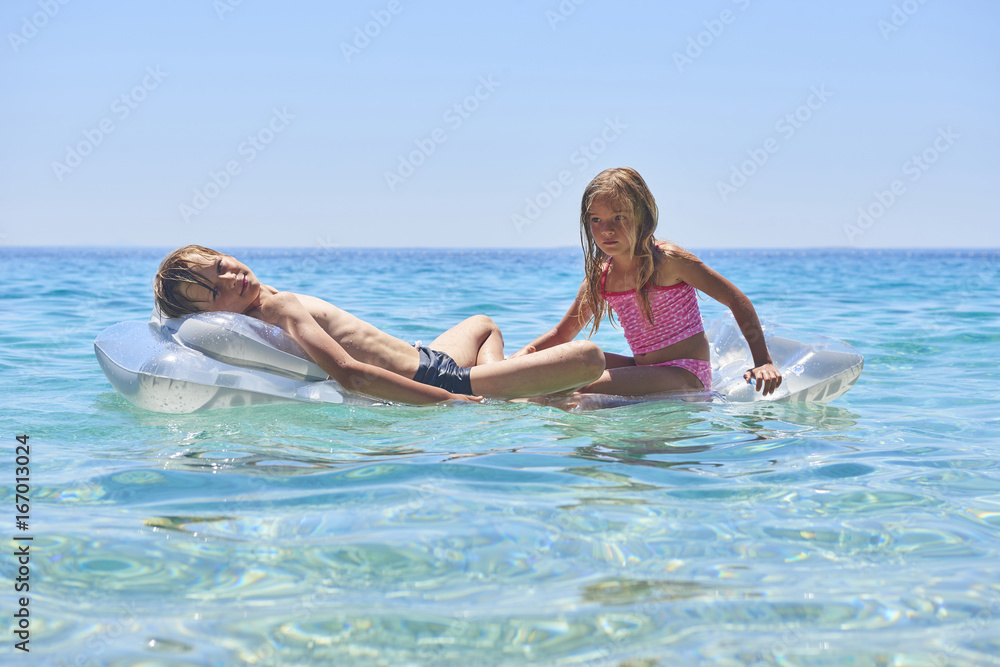 Φωτογραφία Happy Sister and Brother Children Playing with Inflatable Mattress at Adriatic Blue Sea, Hvar island, Croatia