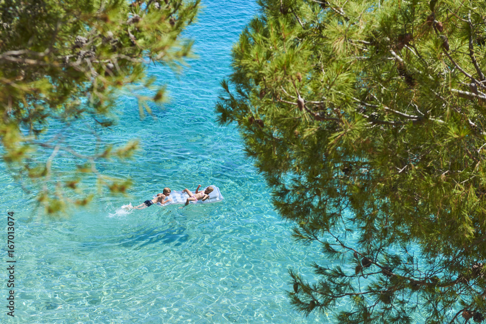 Φωτογραφία Happy Sister and Brother Children Playing with Inflatable Mattress at Adriatic Blue Sea, Hvar island, Croatia