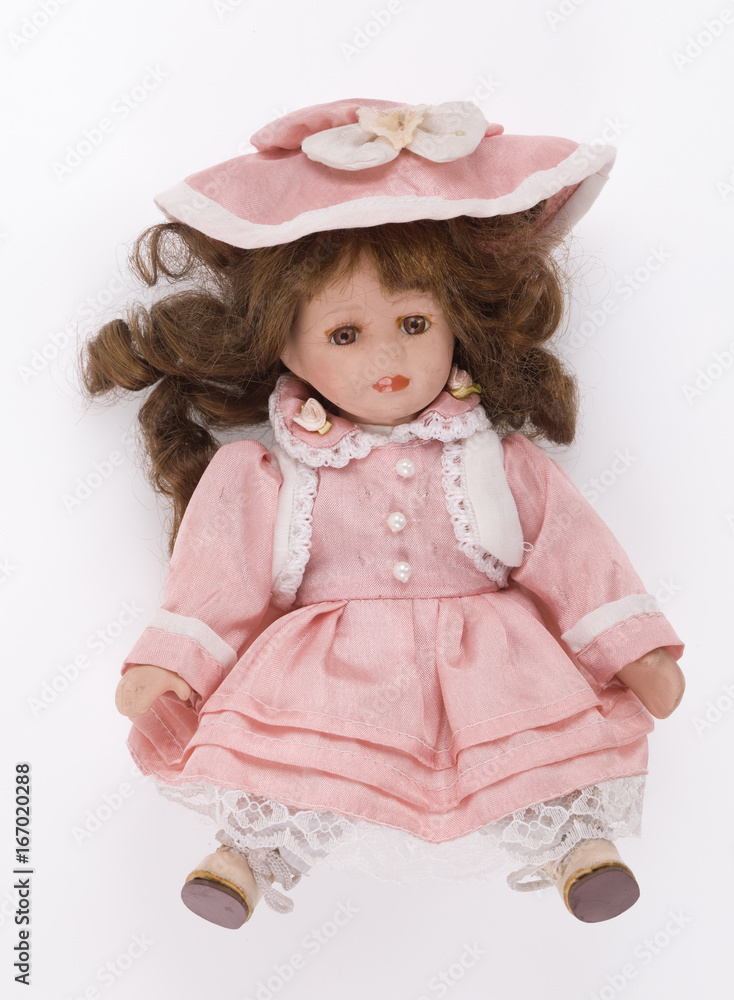 Old doll in a pink dress on a white background Old doll in a pink dress on a white background