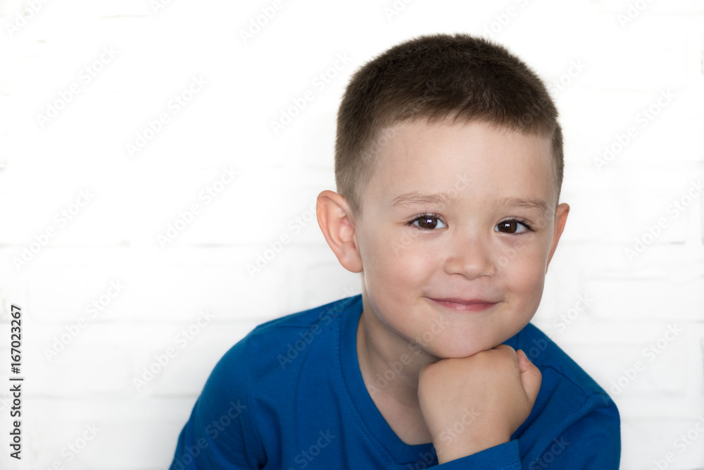 Young boy wearing blue jacket smiling while looking at camera. Young boy wearing blue jacket smiling while looking at camera.