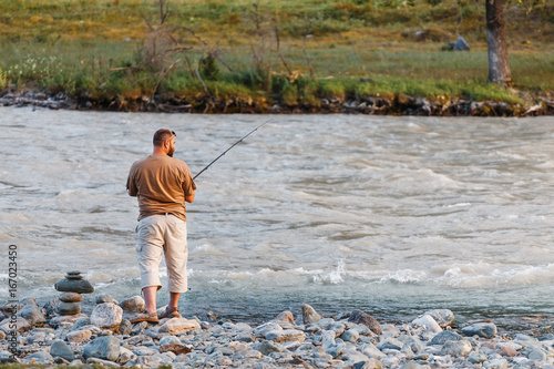 Man Fishing on the mountain rough river