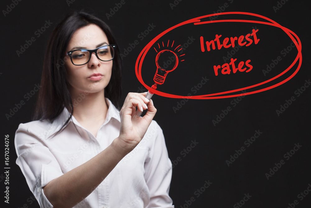 The concept of business, technology, the Internet and the network. A young entrepreneur working on a virtual screen of the future and sees the inscription: Interest rates The concept of business, technology, the Internet and the network. A young entrepreneur working on a virtual screen of the future and sees the inscription: Interest rates