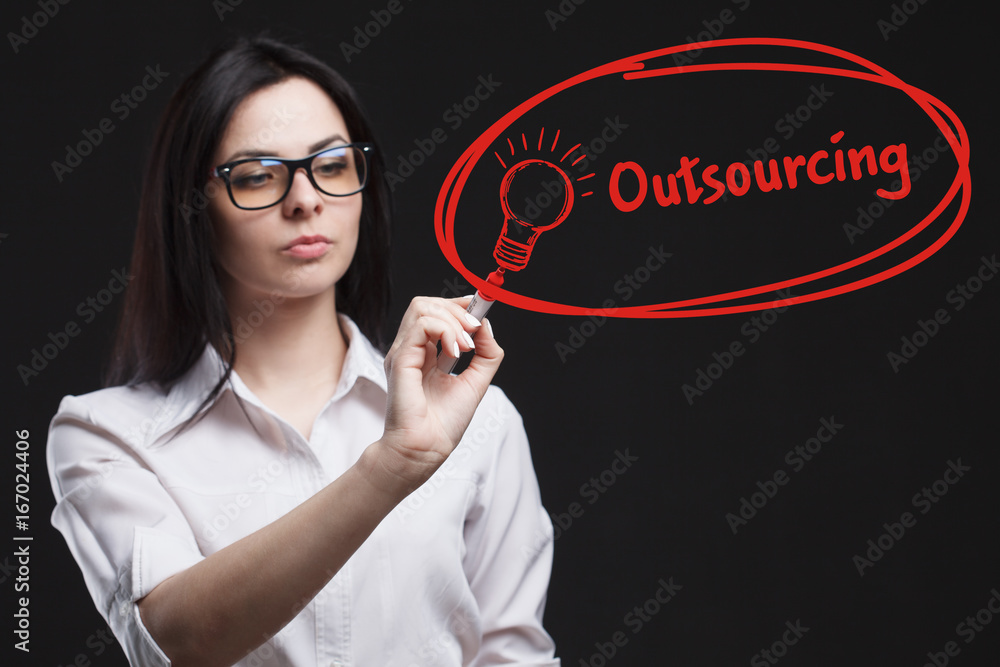 The concept of business, technology, the Internet and the network. A young entrepreneur working on a virtual screen of the future and sees the inscription: Outsourcing The concept of business, technology, the Internet and the network. A young entrepreneur working on a virtual screen of the future and sees the inscription: Outsourcing