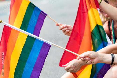 Hands holding gay pride flags 