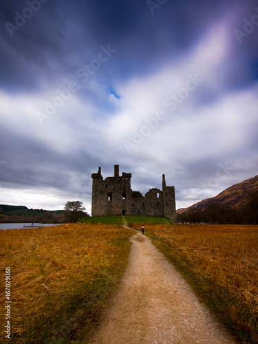 Lonely kid walking towards an old castle