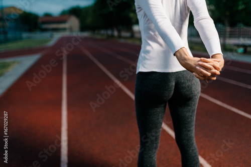 Woman stretching out on a running field