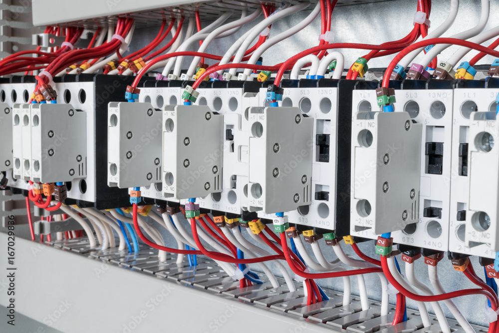 Several contactors arranged in a row in an electrical closet. Several contactors arranged in a row in an electrical closet.