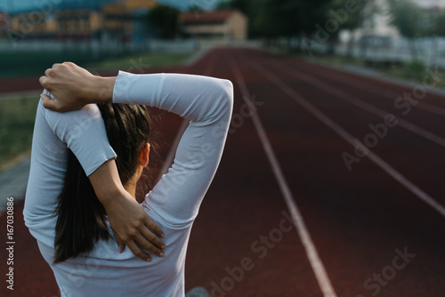 Fit young woman stretching her upper body before a run