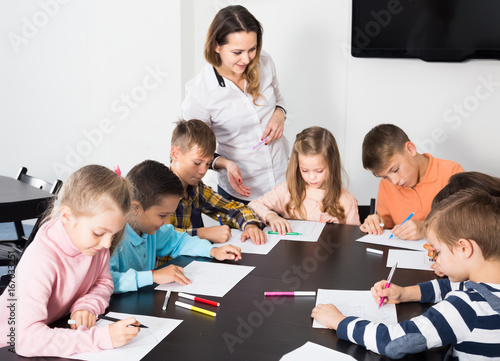 Elementary age children drawing at classroom in school