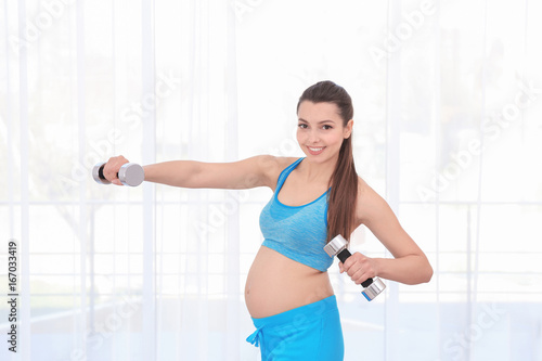 Young pregnant woman traini...