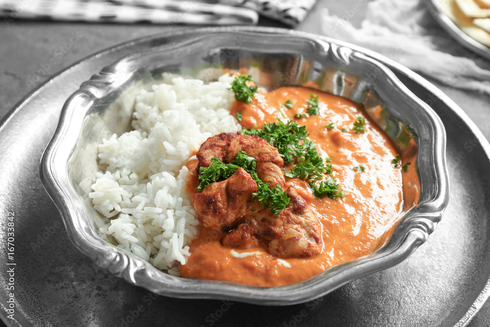 Plate with delicious Murgh Makhani and rice on table Plate with delicious Murgh Makhani and rice on table